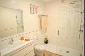 a bathroom with a shower and a toilet and a sink at Leo Canela in Isla Canela