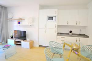 a living room with a table and chairs and a kitchen at Leo Canela in Isla Canela