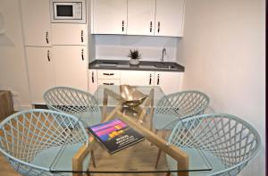 a glass table with four chairs and a book on it at Leo Canela in Isla Canela