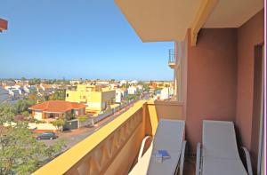 a balcony with chairs and a view of a city at Leo Canela in Isla Canela