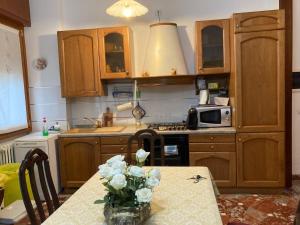 a kitchen with a table with a vase of flowers on it at Casa Vacanza a Limbiate in Limbiate +24 photos