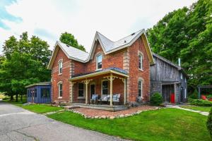 una casa de ladrillo con techo de gambrel en Bohemian Room in a 150-Year-Old Victorian House, en Orangeville