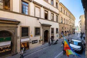 grupa ludzi idąca ulicą z flagą w obiekcie Guicciardini Apartment we Florencji