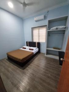 a bedroom with a bed in a room with a window at IBAI COTTAGE KUALA TERENGGANU (HOMESTAY) in Kuala Terengganu