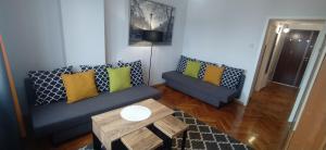 a living room with two couches and a coffee table at Hey Apartments in Warsaw