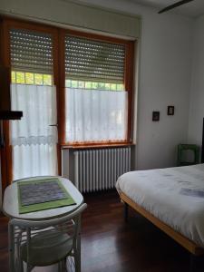 a bedroom with a bed and a table and windows at B&B Bondi in Ravenna