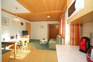 eine Küche und ein Wohnzimmer mit einem Tisch und einem Sofa in der Unterkunft Landhaus Steiner in Schladming
