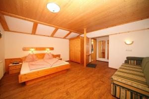 um quarto grande com uma cama e um sofá em Landhaus Steiner em Schladming