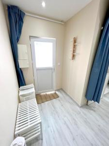 um quarto com uma porta e uma cama com cortinas azuis em Toulouse : Studio équipé au cœur de St-Cyprien em Toulouse