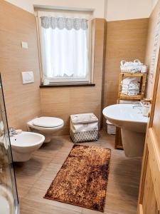 La salle de bains est pourvue de toilettes et d'un lavabo. dans l'établissement Appartamento Valmaor, à Predazzo