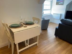 una mesa de comedor con platos encima en Apartment - Centre of Swanage Stunning Sea views, en Swanage