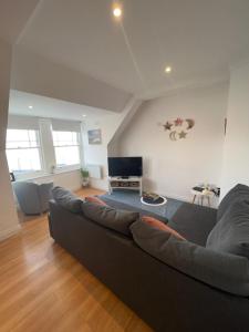 a living room with a couch and a television at Apartment - Centre of Swanage Stunning Sea views in Swanage