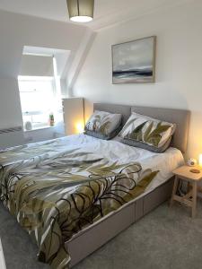 a large bed in a bedroom with a table at Apartment - Centre of Swanage Stunning Sea views in Swanage