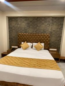 a bedroom with a large bed with a brown headboard at Hotel Pearl View - Near US Embassy BKC in Mumbai