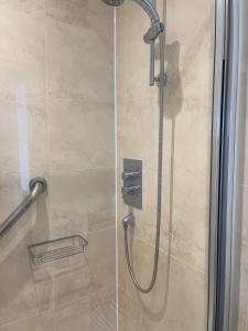 y baño con ducha con cabezal de ducha. en Apartment - Centre of Swanage Stunning Sea views, en Swanage