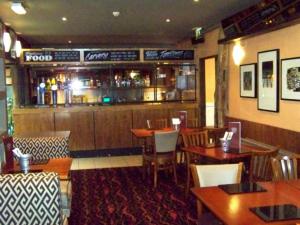 a restaurant with tables and chairs and a bar at Waterford Lodge Hotel in Morpeth