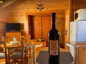 una botella de vino sentada en una mesa en una cabaña en Cabañas El Descansito, en Chillarón de Cuenca