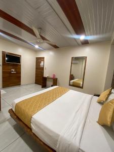 a bedroom with a large bed and a mirror at Hotel Pearl View - Near US Embassy BKC in Mumbai