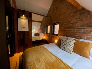a bedroom with a bed and a brick wall at Stunning 3BD Character House near Coleshill in Birmingham