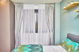 a bedroom with a window with white curtains at Waypoint Suites in Dakar