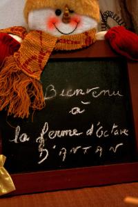 a santa claus is standing next to a chalkboard at A L'Antan - La Ferme D'Octave in Saint-Hilaire-de-Villefranche