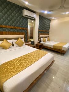 a hotel room with two beds and a mirror at Hotel Pearl View - Near US Embassy BKC in Mumbai