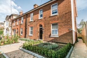 a red brick building with a courtyard in front of it at 14 Helena House Lux Apartment in Reading