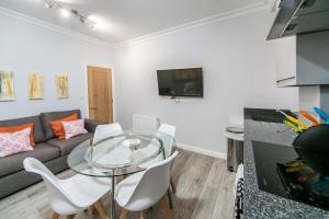 a living room with a glass table and a couch at 14 Helena House Lux Apartment in Reading