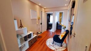 a living room with a blue chair in a room at N3 Apartment in Amadora