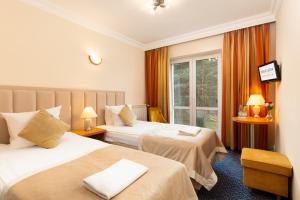 a hotel room with two beds and a window at Perła Leśna Nadarzyn in Nadarzyn