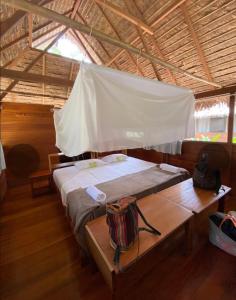 a bedroom with a bed and a table in a tent at Ecolucerna Lodge Tambopata in Puerto Maldonado