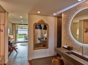 ein Badezimmer mit einem großen Spiegel und einem Waschbecken in der Unterkunft Strandhotel Schmerikon in Schmerikon