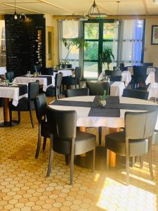 une salle à manger avec des tables et des chaises dans un restaurant dans l'établissement Kyriad Annecy Nord - Epagny, à Metz-Tessy