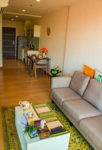 een woonkamer met een bank en een tafel bij 1b-design-50sqm-Astra-ChiangMai in Chiang Mai