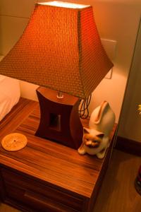 een lamp en een kattenbeeld op een nachtkastje bij 1b-design-50sqm-Astra-ChiangMai in Chiang Mai