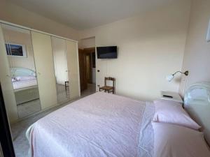 ein Schlafzimmer mit einem großen weißen Bett und einem Spiegel in der Unterkunft Appartamento 10 m dal mare Casa da zia Lena Maiori in Maiori
