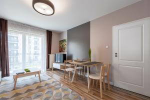 a living room with a dining room table and chairs at Luxury in City -8- Free Parking in Łódź