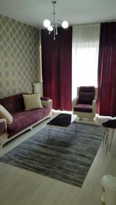 uma sala de estar com um sofá roxo e duas cadeiras em Express24 1+1Fun in the middle of the city 81 em Istambul