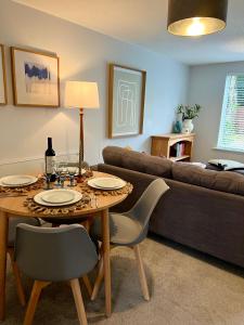 een woonkamer met een tafel en een bank bij Chic 2BR Haven - Contemporary Flat in Hoddesdon in Hoddesdon