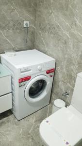 uma máquina de lavar roupa na casa de banho ao lado de um WC em Express24 1+1Fun in the middle of the city 81 em Istambul