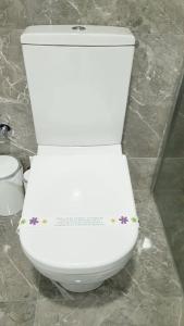 um WC branco com flores na casa de banho em Express24 1+1Fun in the middle of the city 81 em Istambul