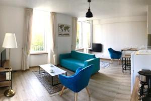 een woonkamer met een blauwe bank en een tafel bij Appartement très lumineux avec belle vue dégagée in Rochefort-en-Terre