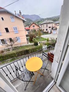 a yellow table and chairs on a balcony with a view at delille pere et fils in Albertville