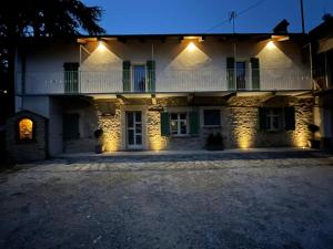 un gran edificio blanco con luces encendidas por la noche en Ca' Ginet, en Cravanzana