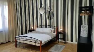 a bedroom with a bed with a black and white striped wall at Belle Vue Ultracentral Apartments in Timişoara