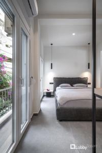 a bedroom with a bed and a large window at La Mer Apartment by LobbySquare in Piraeus