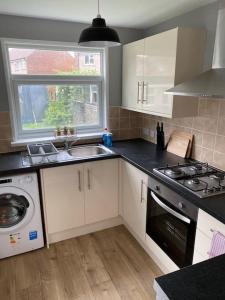 a kitchen with a sink and a stove and a window at Pontymister Retreat in Risca