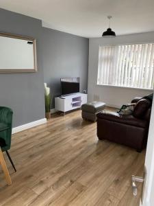 a living room with a couch and a television at Pontymister Retreat in Risca