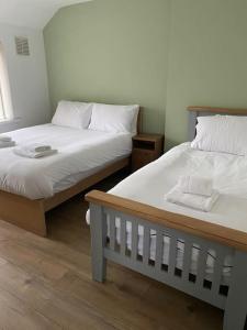 dwa łóżka siedzące obok siebie w pokoju w obiekcie Pontymister Retreat w mieście Risca