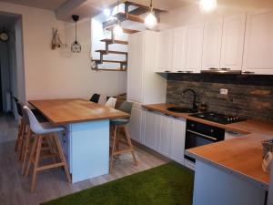 une cuisine avec des placards blancs et un comptoir en bois dans l'établissement Casa din vale, à Bran